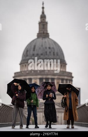 Des personnes portant des parapluies marchant sous la pluie sur Millennium Bridge, Londres, après que des parties de l'Angleterre aient été battues par de fortes pluies et des inondations dans les premières heures de vendredi. Date de la photo : vendredi 27 septembre 2024. Banque D'Images