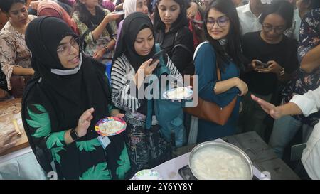 Dhaka. 27 septembre 2024. Les gens goûtent à la cuisine chinoise dans un étal lors de l'événement 'Dhaka China Day' à Dhaka, au Bangladesh, le 24 septembre 2024. Le premier événement « Journée chinoise de Dhaka », co-organisé mardi par l'ambassade de Chine au Bangladesh et l'Université Nord-Sud, a attiré près de 50 000 personnes, dont des personnalités de divers secteurs du Bangladesh et de Chine, ainsi que des résidents locaux et des étudiants universitaires. POUR ALLER AVEC '1er événement de la Journée de la Chine de Dhaka tenu dans la capitale du Bangladesh' crédit : Xinhua/Alamy Live News Banque D'Images