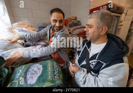 Offenbach am main, Allemagne. 13 septembre 2024. Un commerçant afghan sert un client dans son magasin du centre-ville d'Offenbach. Environ deux tiers des 135 000 habitants d'Offenbach ont un passé migratoire. Crédit : Boris Roessler/dpa/Alamy Live News Banque D'Images