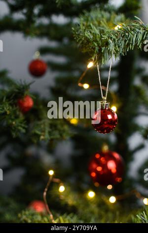 Décorations de Noël rouges sur un arbre de noël, boules d'arbre de noël rouges scintillantes sur un arbre artificiel, vue rapprochée des ornements d'arbre de noël rouges Banque D'Images