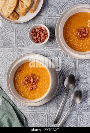 Photographie culinaire de soupe de lentilles rouges avec Chili et bacon, carotte, oignon, ail, pain grillé, bouillon, bouillon, set table Banque D'Images