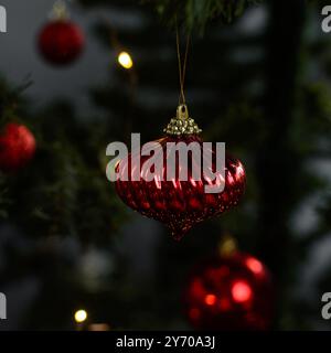 Décorations de Noël rouges sur un arbre de noël, boules d'arbre de noël rouges scintillantes sur un arbre artificiel, vue rapprochée des ornements d'arbre de noël rouges Banque D'Images