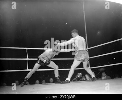 WOODCOCK V MILLS COMBAT Bruce Woodcock, champion britannique, britannique, d'empire et européen des poids lourds, a rencontré le détenteur du titre mondial des poids lourds légers, Freddie Mills, dans un combat de championnat de 15 rounds à la White City, Londres ce soir. Sur le chemin-dans cet après-midi Woodcock avait un avantage de poids d'une pierre 16 lb . Il a escaladé 13 pierre 13 1/2 lb., et Mills 12 pierre 7 1/2 lb. Le vainqueur de ce concours important rencontrera probablement Lee Savold en septembre après le titre mondial des poids lourds. L'IMAGE MONTRE:- Freddie Mills (à gauche) et Bruce Woodcock échangeant des coups de poing pendant leurs combats de championnat ton Banque D'Images