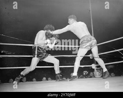 WOODCOCK V MILLS COMBAT Bruce Woodcock, champion britannique, britannique, d'empire et européen des poids lourds, a rencontré le détenteur du titre mondial des poids lourds légers, Freddie Mills, dans un combat de championnat de 15 rounds à la White City, Londres ce soir. À la pesée cet après-midi Woodcock avait un avantage de poids d'une pierre 16 lb . Il a escaladé 13 pierre 13 1/2 lb., et Mills 12 pierre 7 1/2 lb. Le vainqueur de ce concours important rencontrera probablement Lee Savold en septembre après le titre mondial des poids lourds. L'IMAGE MONTRE:- Freddie Mills (à gauche) et Bruce Woodcock échangeant des coups de poing pendant leurs combats de championnat ton Banque D'Images