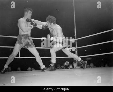 WOODCOCK V MILLS COMBAT Bruce Woodcock, champion britannique, britannique, d'empire et européen des poids lourds, a rencontré le détenteur du titre mondial des poids lourds légers, Freddie Mills, dans un combat de championnat de 15 rounds à la White City, Londres ce soir. À la pesée cet après-midi Woodcock avait un avantage de poids d'une pierre 16 lb . Il a escaladé 13 pierre 13 1/2 lb., et Mills 12 pierre 7 1/2 lb. Le vainqueur de ce concours important rencontrera probablement Lee Savold en septembre après le titre mondial des poids lourds. L'IMAGE MONTRE:- Freddie Mills (à gauche) et Bruce Woodcock échangeant des coups de poing pendant leurs combats de championnat t Banque D'Images