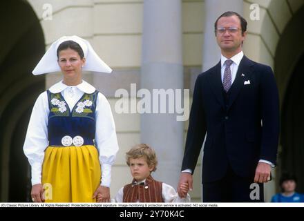 Le roi Carl XVI Gustave de Suède avec la reine Silvia de Suède vêtue d'un costume traditionnel suédois avec son fils le prince Carl Philip, assistant à la cérémonie de célébration de la fête nationale de la Suède au Musée Skansen à Stockholm le 6 juin 1984. Banque D'Images