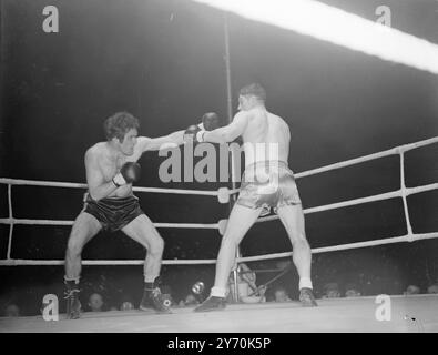 WOODCOCK V MILLS COMBAT Bruce Woodcock, champion britannique, britannique, d'empire et européen des poids lourds, a rencontré le détenteur du titre mondial des poids lourds légers, Freddie Mills, dans un combat de championnat de 15 rounds à la White City, Londres ce soir. Sur le chemin-dans cet après-midi Woodcock avait un avantage de poids d'une pierre 16 lb . Il a escaladé 13 pierre 13 1/2 lb., et Mills 12 pierre 7 1/2 lb. Le vainqueur de ce concours important rencontrera probablement Lee Savold en septembre après le titre mondial des poids lourds. L'IMAGE MONTRE:- Freddie Mills (à gauche) et Bruce Woodcock échangeant des coups de poing pendant leurs combats de championnat ton Banque D'Images