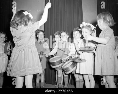 CUIVRES SONORES ... symboles Tinkling et tambours battants se combinent dans une symphonie de jeunesse dans l'Archway Central Hall , Highgate , Londres . Le groupe de percussions de Dominic's Infants ' School, N.W., 5. Sous la baguette vigoureuse de PAULINE SHEEHAN, cinq ans, et vu en compétition au North London Music Festival.- ils ont été entrés dans la classe pour le groupe de percussions avec des joueurs de huit ans et moins . 18 mai 1949 Banque D'Images