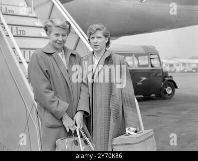 LES STARS DU TENNIS REGARDENT EN photo à leur arrivée à l'aéroport de Londres par le Clipper panaméricain sont la championne de Wimbledon Miss Louise Borough ( à gauche ) et son partenaire de double , la championne américaine Mme Margaret Osborne Dupont . Ils sont les premiers d'une vague de stars américaines du tennis sur gazon envahissant l'Europe et ce pays cet été. Leur séjour ici sera court, car ils doivent partir pour Paris presque immédiatement pour participer au championnat de France. Ils retourneront cependant en Angleterre le 1er juin , le lendemain de la fin des championnats de France . 15 mai 1949 Banque D'Images