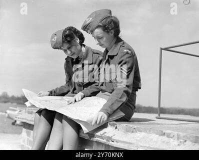 LES FILLES DE L'AIR TRACENT LEUR ITINÉRAIRE deux membres du Women's Junior Air corps à l'aérodrome d'Elstree ( Herts. ) - Dorothy Knowles ( à gauche ) et Joan Lee , de Dagenham , étudient une carte de la région pendant les leçons élémentaires qu'ils suivent en vol . La saison de vol a commencé à Elstree aujourd'hui , et environ 100 filles âgées de 14 à 20 ans auront l'occasion de monter dans le propre avion du corps ''Grey Dove '', qui a été nommé par la duchesse de Kent lors du grand rassemblement national du corps l'été dernier . 23 avril 1949 Banque D'Images