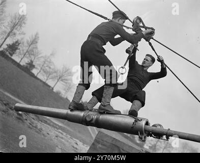 NAVI'S ' SERRÉ - CORDE ' ACT ' aéroporté ' opération par les hommes de la marine à H.M.S. excellent , Portsmouth , alors que les marins s'entraînent pour le terrain - compétition d'armes à feu au tournoi Royal de cette année . Équilibré sur le canon - canon et se préparer pour un rapide ' mouvement ' sont ordinaires - Seaman T . MOULINS de lecture ( à gauche ) et Able - marin R. BOSWORTH de Coventry . Le tournoi Royal , exposition annuelle par les services , a lieu à Olympia , Londres , en juin . 30 mars 1949 Banque D'Images