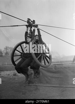 SANGLE - SUSPENDUE - STYLE NAVAL Un lourd fardeau repose sur les épaules robustes de ces jeunes marins - qui ne pourraient pas tenir plus fermement si un abîme bâillait en dessous - alors qu'ils balancent dans l'espace avec une paire de roues de canon à H.M.S. excellent , Portsmouth , où les équipes de la marine pour le terrain - compétition de canon au tournoi Royal de cette année sont déjà en formation . Les hommes sont ordinaires - Seaman W . ROUSSE de Hove ( gauche ) et Able - marin M . DERNIER de Ilford . Le tournoi Royal , exposition annuelle par les services , prend le palais à Olympia , Londres , n juin . 30 mars 1949 Banque D'Images