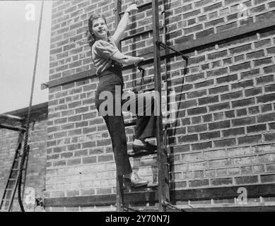 STEEPLEJILL EST Une BALLERINE apparaissant dans un théâtre de Leeds en tant que ballerine, Sheila Picard, 16 ans, a pris congé de la scène pour grimper une cheminée de 120 pieds de haut pour apporter thé et sandwichs à son père, qui travaillait au sommet. Membre d'une famille de steeplejack, Sheila a fait sa première montée quand elle avait 12 ans, et depuis lors, elle paie un appel sur le toit à son père chaque fois que possible. Escalader les hauteurs, cependant, n'est que son passe-temps, car elle est déterminée à faire de cette étape sa carrière. L'IMAGE MONTRE:- Sheila Pickard montant la cheminée de 120 pieds de haut à Leeds. 21 juillet 1949 Banque D'Images