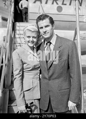 ANGELA'S GOING AWAT HAT actrice de cinéma d'origine anglaise Angela Lansbury qui a volé ici d'Hollywood pour devenir Mrs . Peter Shaw portait ce joli foulard sur lequel le mot ' Londres ' apparaît lorsqu'elle a quitté l'aéroport de Londres avec son mari pour retourner en Amérique , le couple a passé leur lune de miel à Paris . IMAGES MONTRENT:- Angela Lansbury avec son mari Peter Shaw avant leur départ de l'aéroport de Londres. 4 septembre 1949 Banque D'Images