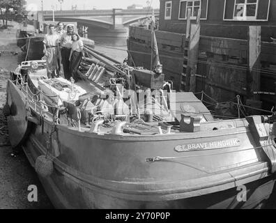 VOYAGE EN BARGE DEPUIS LA TAMISE accompagné de sa femme et d'un équipage de deux personnes, Jack Bilbo - auteur , peintre et sculpteur de Weybridge Surrey - est sur le point de partir de Chelsea, Londres , au début d'un voyage autour du monde dans une barge néerlandaise vieille de 54 ans, ' de Brave Hendrik '. Pendant le voyage , Mme Bilbo prendra en charge la galère , tandis que M. . Bilbo prendra en charge la galerie , tandis que M. . Bilbo agit en tant que Skipper . Ses deux ' mains ' sont Joe Benjamin , 21 ans, et Harry Kelly , 24 ans, tous deux de Chelsea la barge , construite en fer et teck , mesure 50 pieds de long et 13,8 pieds dans l'équipe . L'IMAGE MONTRE:- D Banque D'Images