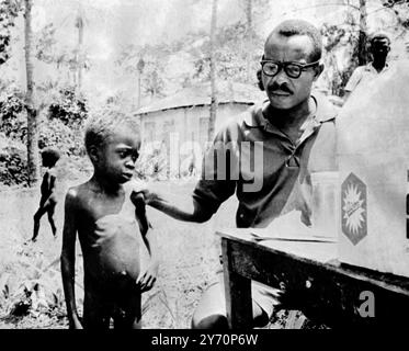 Un petit garçon à moitié affamé est examiné par un médecin dans un camp de réfugiés du Biafra avant de recevoir de la nourriture et des médicaments , Biafra 6 août 1968 Banque D'Images