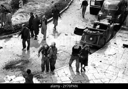 Un terroriste arabe a fait exploser une partie du bâtiment de l'Agence juive à Jérusalem jeudi dernier. Dans les ravages de l'explosion et de l'incendie qui a suivi dix Juifs sont connus pour avoir trouvé la mort et 86 autres blessés. L'explosion s'est produite peu de temps après qu'une berline bleue , portant les numéros du consulat américain et volant les étoiles et Stipes , ait balayé la voiture courbe en chaussures à cheval à la suite du bâtiment . Le conducteur arabe a été vu quitter la voiture et un moment ou deux plus tard, deux caisses d'emballage qu'il avait laissées derrière ont explosé avec une force terrible. Vu ici des victimes étant emportées après l'explosion. 14 mars 1948 Banque D'Images