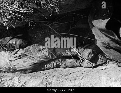 Les rapports juifs qui sont venus à Londres par avion avec cette photo affirment que les Arabes combattant dans le village de Kakoun , à 6 kilomètres de Tulkarem , avaient les pieds attachés ensemble dans les tranchées pour s'assurer qu'ils ne pourraient pas battre en retraite . Quand les Juifs ont pris le village, ils ont trouvé des morts arabes couchés dans les tranchées avec leurs pieds encore attachés ensemble. Vu ici des Arabes morts couchés dans les tranchées du village de Kakoun . 16 juin 1948 Banque D'Images