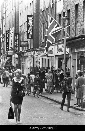 Le centre de la mode londonien pour les plus jeunes est Carnaby Street, la rue la plus connue, sinon la plus populaire de Londres. Les jeunes aux cheveux longs parlent loin les heures à Carnaby Street la Mecque des modes mod de la capitale anglaise tout au long de la mini-jupes aux derniers styles en vestes et pantalons pour hommes peut être acheté à Carnaby Street, la mode des jeunes HQ20 juillet 1967 Banque D'Images