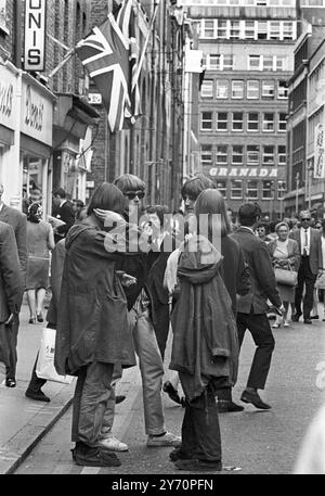 Le centre de la mode londonien pour les plus jeunes est Carnaby Street, la rue la plus connue, sinon la plus populaire de Londres. Les jeunes aux cheveux longs parlent loin les heures à Carnaby Street la Mecque des modes mod de la capitale anglaise tout au long de la mini-jupes aux derniers styles en vestes et pantalons pour hommes peut être acheté à Carnaby Street, la mode des jeunes HQ20 juillet 1967 Banque D'Images