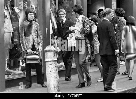 Le centre de la mode londonien pour les plus jeunes est Carnaby Street, la rue la plus connue, sinon la plus populaire de Londres. Les jeunes aux cheveux longs parlent loin les heures à Carnaby Street la Mecque des modes mod de la capitale anglaise tout au long de la mini-jupes aux derniers styles en vestes et pantalons pour hommes peut être acheté à Carnaby Street, la mode des jeunes HQ20 juillet 1967 Banque D'Images