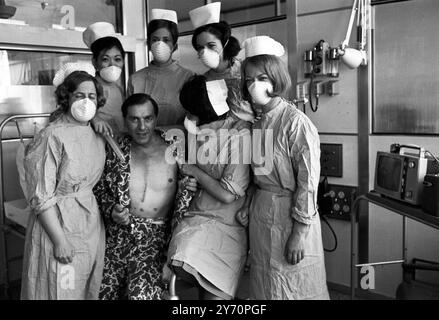 M. Frederick West 45 , de Leigh-on-Sea , premier transplanté cardiaque de Grande-Bretagne , au National Heart Hospital , Marylebone , Londres , aujourd'hui , avec sa poitrine cousue , pose avec son équipe d'infirmières dans sa suite hospitalière spéciale . Hier , M. West a été déplacé du théâtre où l'opération a eu lieu il y a trois semaines et trois jours , dans sa propre suite d'hôpital . M. West a reçu le coeur du charpentier Irlandais , M. Patrick Ryan , 26 ans , décédé suite à une chute d'un chantier de construction . 28 mai 1968 Banque D'Images