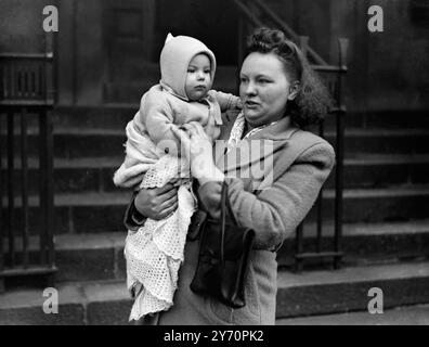 Vêtu d'un costume de laine bleu, Raymond Larry Ward, âgé de sept mois, d'Agar Grove, que le policier londonien a recherché pendant huit heures hier, après avoir été manqué de sa poussette, a dormi paisiblement chez sa grand-mère, au tribunal de première instance de Clerkenwell aujourd'hui. Sa mère, Mme Elsie Ward, a également été importante lorsque Muriel Locke, 19 ans, de Nathanial Road, Devonshire, a été accusée d'avoir emmené Raymond à Rochester Square hier. Images : Raymond est assis serré dans les bras de sa mère après son aventure. 9 janvier 1948 Banque D'Images