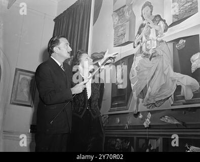 Salvador Dali discute avec son épouse Gala de sa peinture la Vierge de Port Lligat, à l'ouverture d'une exposition de son travail. 40 œuvres de Dali exposées lors d'une exposition aux Leferve Galleries de Bruton Street, London2 décembre 1951 Banque D'Images