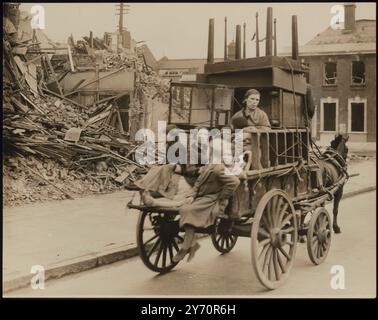 TREK FROM THE EASTPHOTO SHOWS : une femme et des enfants, bombardés hors de leurs maisons par des raids nazis, passant devant des bâtiments en ruine alors qu'ils quittent l'East End de Londres à la recherche d'un nouvel abri. Empilé sur le chariot tiré par poney est des meubles récupérés, y compris une cage de budgerigars. 22 septembre 1940 Banque D'Images