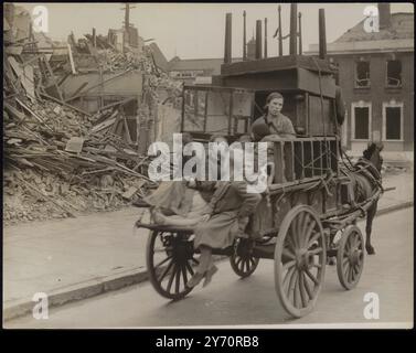 TREK FROM THE EASTPHOTO SHOWS : une femme et des enfants, bombardés hors de leurs maisons par des raids nazis, passant devant des bâtiments en ruine alors qu'ils quittent l'East End de Londres à la recherche d'un nouvel abri. Empilé sur le chariot tiré par poney est des meubles récupérés, y compris une cage de budgerigars. 22 septembre 1940 Banque D'Images