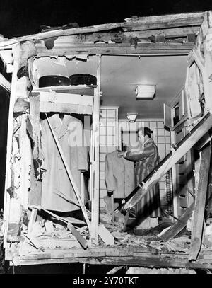 Mickey Cohen , le petit joueur-habilleur qui a été plusieurs fois la cible d'assassins , regarde les dommages causés à sa garde-robe après qu'une explosion a brisé le fond de sa maison à Los Angeles , le 6 février 1950. La police croit que l'explosion a été causée par une bombe de gangland . Personne n'a été blessé . Meyer Harris 'Mickey' Cohen (4 septembre 1913 - 29 juillet 1976) était un gangster américain basé à Los Angeles et patron de la famille Cohen. Il avait également des liens étroits avec la mafia italo-américaine des années 1930 aux années 1960 Banque D'Images