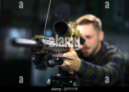 Leipzig, Allemagne. 27 septembre 2024. Un homme regarde à travers le viseur télescopique du fusil de précision Haenel LR/ONE Blick sur le stand du fabricant d'armes à feu de Thuringe au salon 'Jagd & Angeln 2024' à Agra. Du 27 au 29 septembre 2024, environ 250 exposants présenteront tout pour les chasseurs et les pêcheurs. En plus d'une large gamme d'armes, d'optiques et d'équipements, il y aura également de nombreuses démonstrations telles que des spectacles aériens, des exercices de tir et des chevaux de dos. Crédit : Jan Woitas/dpa/Alamy Live News Banque D'Images