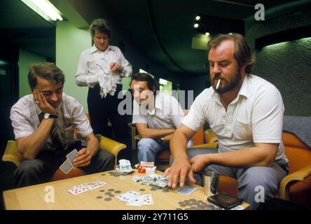 Jouer à un jeu de cartes pour de l'argent. Deux hommes jouant, fumeurs et collègues regardant. Pièces de monnaie sur la table Londres Angleterre circa années 1995 1990 Royaume-Uni HOMER SYKES Banque D'Images