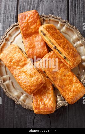 Pain Suisse ou pain suisse est une pâtisserie française traditionnelle qui se vante de couches de pâte au beurre enveloppant la garniture de crème anglaise avec le chocolat gros plan sur le Banque D'Images