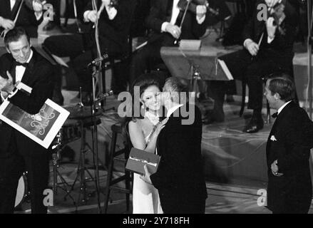 Cannes : le réalisateur britannique Lindsay Anderson , qui a reçu le Grand Prix du Festival de Cannes pour son film " If " , embrasse chaleureusement la star italienne Claudia Cardinale , après qu'elle lui ait remis le prix ici le 23 mai 1969 Banque D'Images