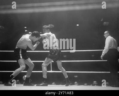 LA VICTOIRE FRANÇAISE SUR LE CHASSEUR BRITANNIQUE RAY FAMECHON , de France , a été déclarée vainqueur aux points sur son adversaire , JOHNNY MOLLOY , de St. Helens ( Lancs 0 dans un concours à Harringay , Londres . IMAGES :- RAY FAMECHONE ( France ) ( à gauche ) s'installe pour échanger des coups de poing avec JOHNNY MOLLOY , lors de leur combat Harringay . 7 février 1949 Banque D'Images