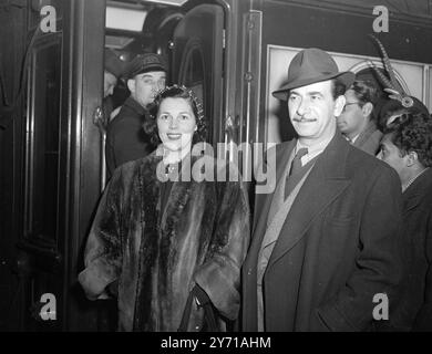 MAURICE WINNICK EN AMÉRIQUE - EST-IL APRÈS UNE NOUVELLE IDÉE DE DIFFUSION? M. MAURICE WINNICK , chef de bande de danse , et Mme . WINNICK quitta Waterloo Station , Londres pour Southampton , où il embarquera sur le QUEEN MARY , Cunard White Star paquebot , pour New York . Ses précédentes visites en Amérique ont été responsables de ''vingt questions'' et ''ignorance is Bliss'' programmes B.B.C. . Cherche-t-il une nouvelle idée ? L'IMAGE MONTRE:- Mr . Maurice Winnick et Mme . Winnick ( portant une coiffe de roman ) photographié à Waterloo Station , Londres . 19 janvier 1949 Banque D'Images