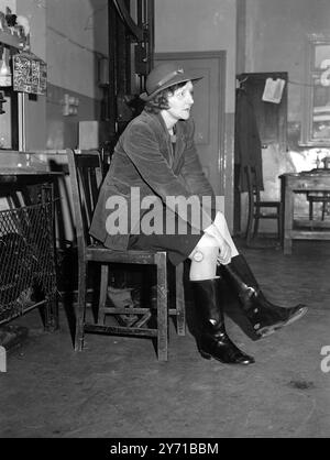 ELLE MARCHE POUR Une Miss '' Peggy'' (MARGARET) ROBERTSHAW , de l'usine Dunlop à Liverpool , a marché plus de 28 000 miles pour tester des chaussures par toutes sortes de temps, dans les rues de la ville et à travers une route de campagne très genre, chaque coin avec un podomètre autour de sa jambe, elle pointe à 8,30 et va à Liverpool ou prend un bus dans le pays environnant, marchant 12 miles , avec une pause pour le repas de midi, pointage à 5,15. Mlle Robershaw marche cinq jours par semaine depuis neuf ans, huit d'entre eux avant la guerre, les chaussures sont également testées dans l'usine où marchent les ouvriers Banque D'Images