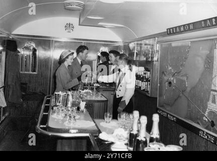 Une image montrant la Tour Eiffel de Paris orne le mur du Trianon Bar , une caractéristique de la nouvelle flèche d'or qui était vue à la gare Victoria de Londres . Nouveauté introduite dans ce bar luxueux sont les sièges debout qui sont rembourrés en cuir et moquette pour correspondre à l'autre rembourrage. Le comptoir de bar lui-même est conçu pour occuper le minimum d'espace au sol et se prête à un regroupement confidentiel autour du comptoir. La flèche d'or , qui a raison de voir le jour en cette année de Fête , entre en service le lundi 11 juin . Par une heureuse coïncidence l'avènement du train a Banque D'Images