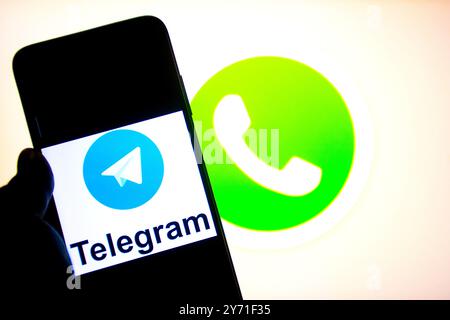 Dans cette illustration photo, un logo Telegram vu affiché sur un smartphone avec un logo WhatsApp en arrière-plan. Banque D'Images