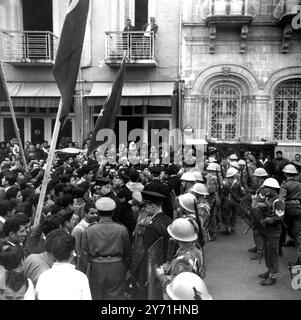 Émeutes chypriotes turcs à Nicosie. Des soldats de l'artillerie royale et de la police font face à des émeutiers chypriotes turcs sur la place Ataturk. Plus d'un millier de Chypriotes turcs criant "à bas le pied (gouverneur Sir Hugh)" se sont battus avec des pierres et des bouteilles jusqu'à ce qu'ils soient dispersés avec des gaz lacrymogènes. La foule criante, réclamant la partition de Chypre, a ignoré un appel de leurs dirigeants à la rupture. Alors que les émeutes ont eu lieu Sir Hugh Foot était en Turquie pour des conférences avec le Minnister étranger, Selwyn Llyod en marge de la réunion du Pacte de Bagdad. 27 janvier 1958 Banque D'Images