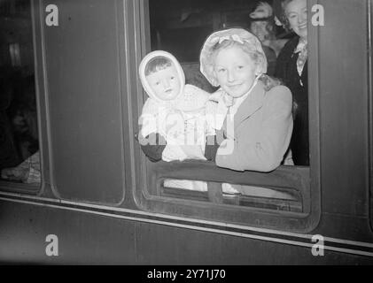 DE NOUVELLES VIES POUR ONZE CENTS le SS ORMONDE met les voiles de Tilbury pour l'Australie aujourd'hui portant 1100 hommes, femmes et enfants britanniques à de nouvelles vies 'Down Under ' bateau-trains de produits Pancras étaient occupés ce matin à les amener au navire tout émigrant. IMAGES MONTRENT:- V.I.P. sur le bateau-train à Tilbury de préparas Pancras ce matin était la poupée hors taille de BETTY MILNE de Liverpool, huit ans, qui est à destination de Bathurst, N.S.W. ici, ils disent au revoir de la fenêtre de la voiture. 21 mai 1948 Banque D'Images