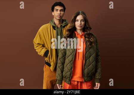 Un couple élégant met en valeur les vêtements d'automne, la chaleur rayonnante et la mode dans des tenues colorées. Banque D'Images