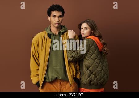 Un jeune couple à la mode présente une tenue d'automne vibrante, dégageant chaleur et style ensemble. Banque D'Images