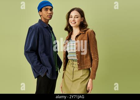 Un couple élégant habillé dans des tenues d'automne montre la confiance et le charme à l'extérieur ensemble. Banque D'Images