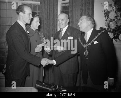 Quand Mlle SYLVIA KEW, 23 ans, d'East Acton et M. STANLEY COOK, 28 ans, de Kensington s'est marié ils étaient le premier couple à se marier au nouveau bureau du registre de Kensington à Cheniston Lodge , Marloes Road , le maire de Kensington , le conseiller J.H. HUXLEY , qui a organisé un service spécial pour marquer l'ouverture du nouveau bureau matrimonial a assisté à la cérémonie avec d'autres conseillers. IMAGES MONTRENT:- le maire de Kensington , le conseiller Huxley félicite le marié après le mariage . Le suppl. Registra C.K. WESTON est vu avec la mariée. 20 novembre 1948 Banque D'Images