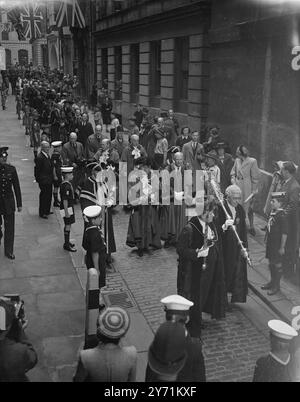 ' SIR FREDERICK HONORE SIR RICHARD ' WHITTINGTON WEEK CEREMONY . Le lord maire de Londres , SIR FREDERICK WELLS , a effectué une visite d'État à l'église blitzed od St. Michael Royal , rue Cannon . , ( Empire Day ) pour inaugurer une semaine de whittington en l'honneur de Sir Richard Whittington , son fondateur en 1407 , et quatre fois maire de Londres . IMAGES MONTRENT:- ' TURN AGAIN WHITTINGTON ' jouant l'air honoré du temps sur les cloches et les trompettes , la procession du MAIRE LORD et des shérifs , descend College Hill , jusqu'à la porte de St. Michael ' s Church , pendant le Whittington Ceremon Banque D'Images