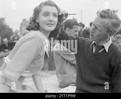 ' Added Beauty ' - ' Passport to Pimlico ' jouant le rôle principal dans le nouveau film britannique ' Passport to Pimlico ' est Barbara Murray qui joue le rôle d'une fille londonienne typique dans cette nouvelle comédie qui vient de la plume de l'auteur de ' Hue and Cry ' , T.E.B. Clarke . C’est une histoire de Londoniens qui trouvent soudain qu’ils sont vraiment Bourguignons. Une ancienne charte découverte , révèle qu'une partie de Pimlico a été présentée à un ancien duc de Bourgogne . Les habitants sont donc techniquement étrangers. Images montrent : ' maquiller l'artiste ' - Barbara Murray se fait maquiller par Harry Frampton sur le site whe Banque D'Images