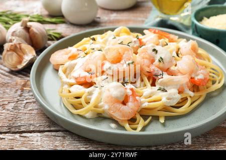 Délicieuses pâtes aux crevettes servies sur une table en bois, gros plan Banque D'Images