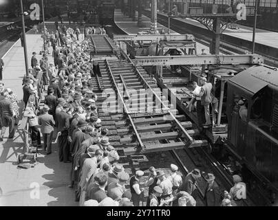 « Everything laid on » - une piste pré-fabriquée posée à Waterloo Southern Region les ingénieurs de British Railways relayent l'ensemble de la piste adjacente au quai 5 entre les heures de pointe du matin et du soir aujourd'hui, à Waterloo Station, à Londres. En utilisant la machine de pose la plus à jour et la voie préfabriquée, les ingénieurs commenceront à 11h et termineront le travail à 15h à temps pour le trafic du soir. L'image montre : - 'Waterloo New look' - Une sélection de la nouvelle voie est transportée par un dispositif de levage. L'ancienne piste est vue ci-dessous, à Waterloo aujourd'hui. 19 juillet 1948 Banque D'Images